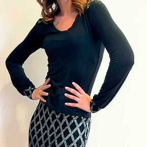 Mujer con un jersey negro y una falda con detalles de color plata.