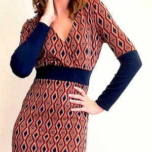 Fotografía de una mujer con un vestido de rombos rojos y negros con un cinturón de tela de color negro.