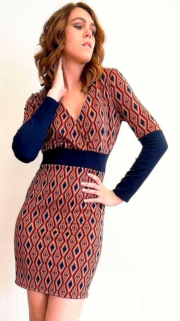 Fotografía de una mujer con un vestido de rombos rojos y negros con un cinturón de tela de color negro.