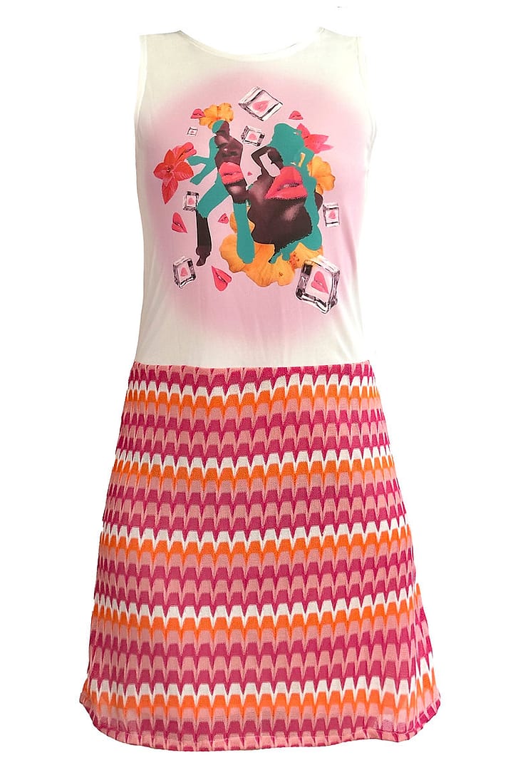 Fotografía de un vestido visto desde detrás con la parte de arriba blanca y una ilustración en el centro de la camiseta y la parte de abajo con una falda con detalles rosas, naranjas y blancos.