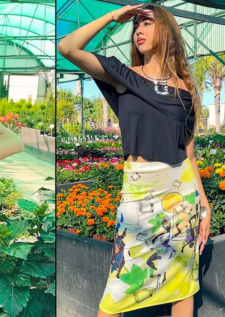 Fotografía en un estudio fotográfico, de una mujer con un top de color negro y una falda larga donde hay motivos de frescura y de africanas.